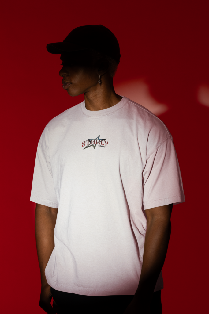 oversized t shirt mockup of a man standing in the spotlight of a studio m50048